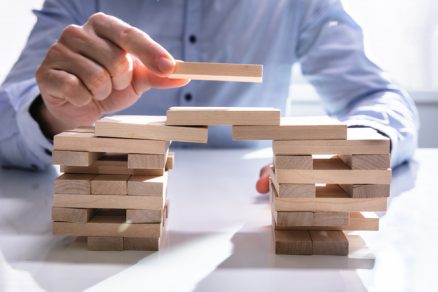 Businessman building a bridge via wooden blocks.